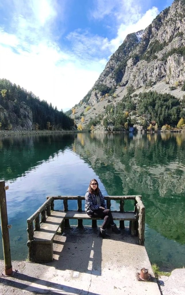 Ibón de Panticosa, un lago de montaña rodeado de impresionantes picos de los Pirineos, con aguas cristalinas reflejando el paisaje natural y bosques de pinos cercanos.