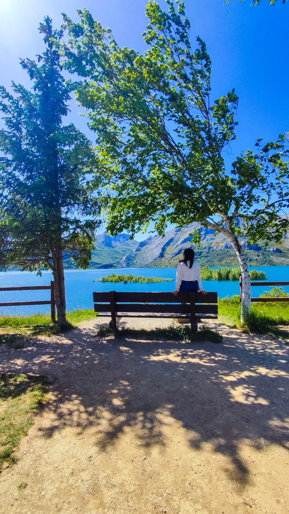 Chica sentada en el Banco más bonito de León con vistas al embalse de Riaño
