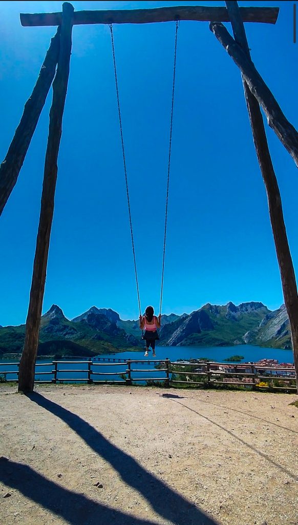 Chica en el mirador del columpio de Riaño con vistas al embalse y pueblo