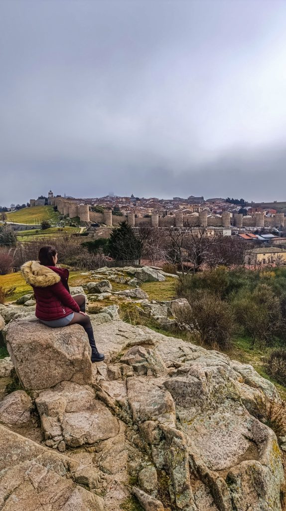 Vista panorámica de Ávila desde el Mirador de los 4 Postes, con la ciudad amurallada al fondo bajo un cielo nublado