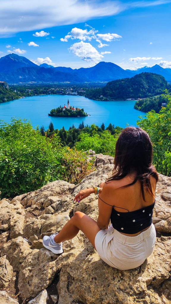 Chica sentada admirando las vistas al Lago Bled desde el Mirador Ojstrica