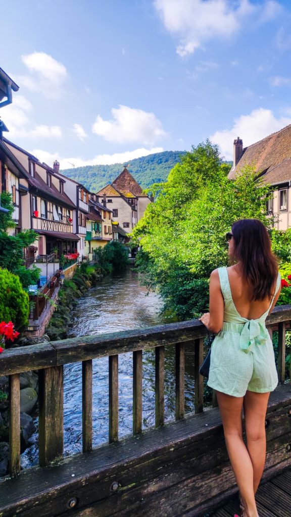 Chica en uno de los puentes de Kaysersberg en Alsacia