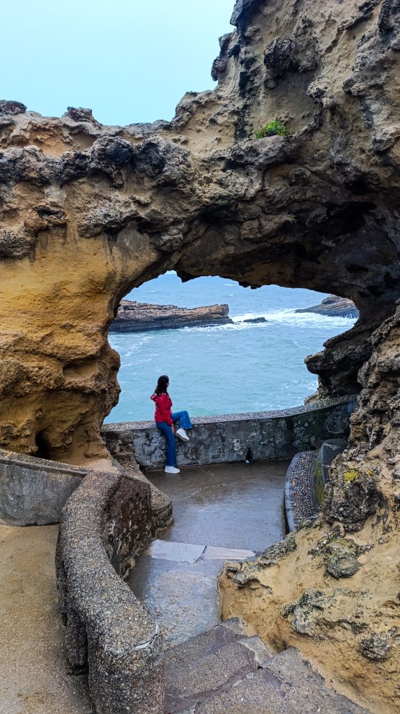Chica en el famoso arco natural de Biarrtiz con el mar al fondo