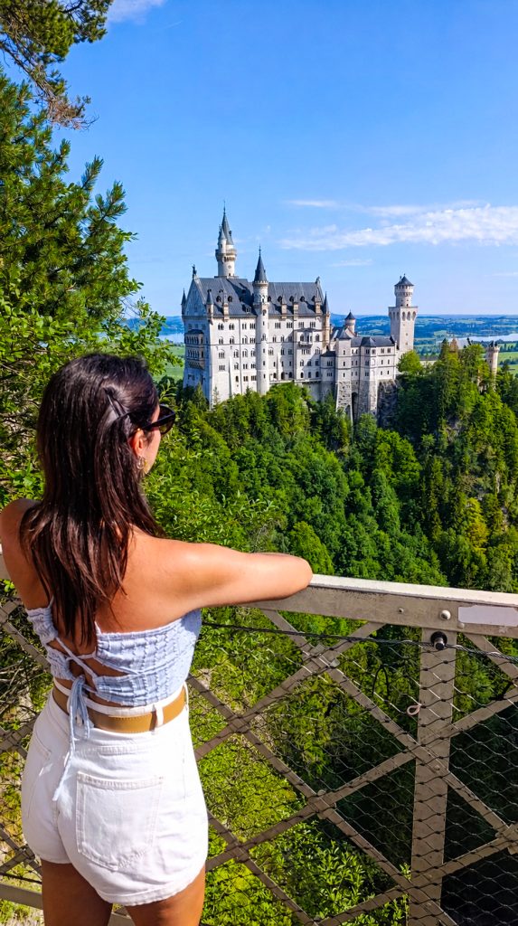 Chica con vistas al Castillo de Neuschwanstein desde Marienbrücke