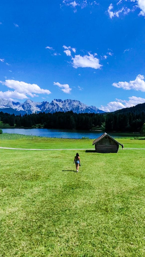 chica en el Lago Geroldsee en los Alpes Bñavaros con las montañas al fondo y las tipicas casas de madera