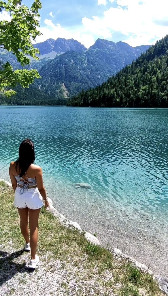 Chica en la orilla del Lago Plansee en los Alpes bávaros
