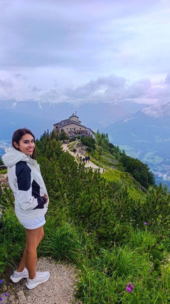 Chica con el Nido del Aguila al fondo en un día nublado