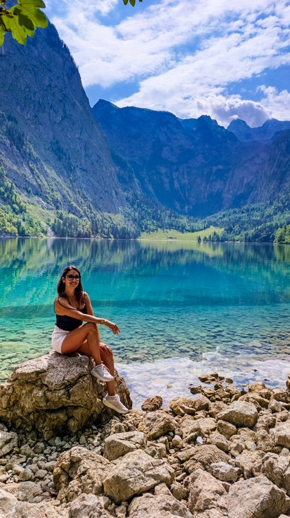 Chica en la orilla de Obersee con sus aguas cristalinas y montañas al fondo