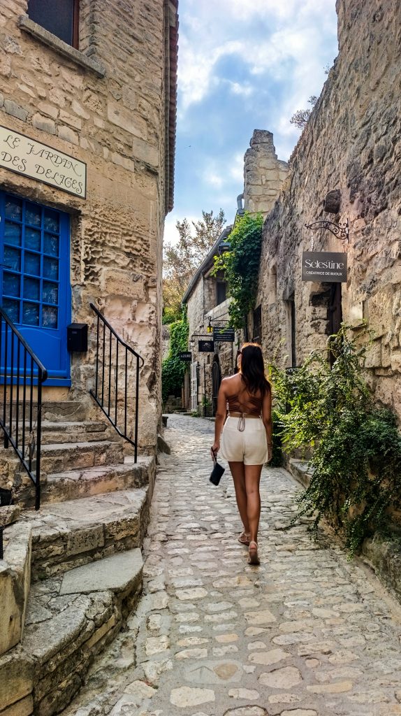 Chica caminando por las calles empedradas de Les Baux de Porvence