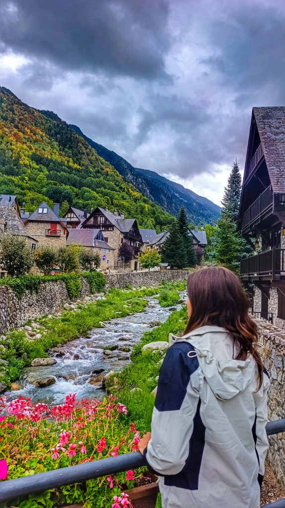 Chica contemplando el río que cruza el pueblo de Arties