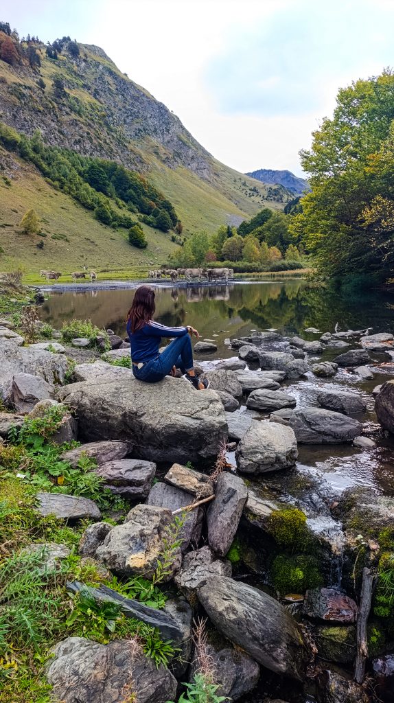 Chica en el entorno de Saut Deth Pish junto a un pequeño lago
